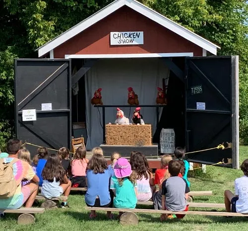 Families watching robotic chicken show at Ellms Farm in Saratoga