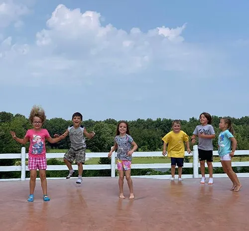 Smiling children bouncing on the Jumping Pillow at Ellms Farm - cropped