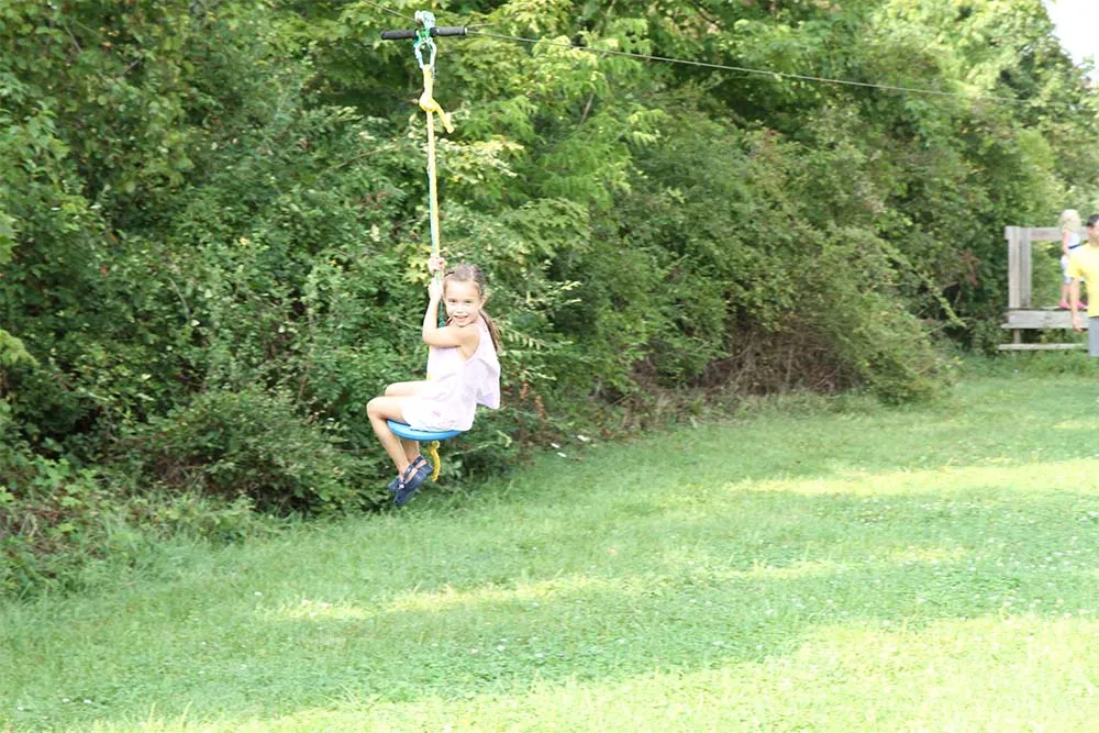 girl riding down zipline having fun