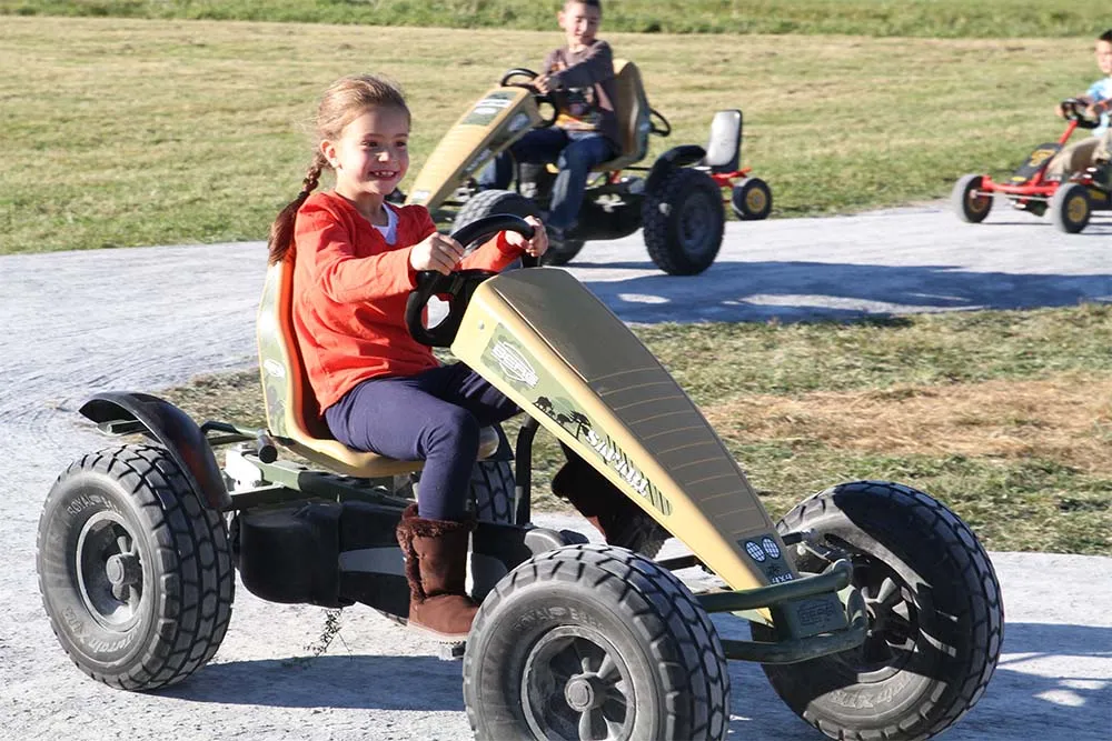 girl driving a pedal cart