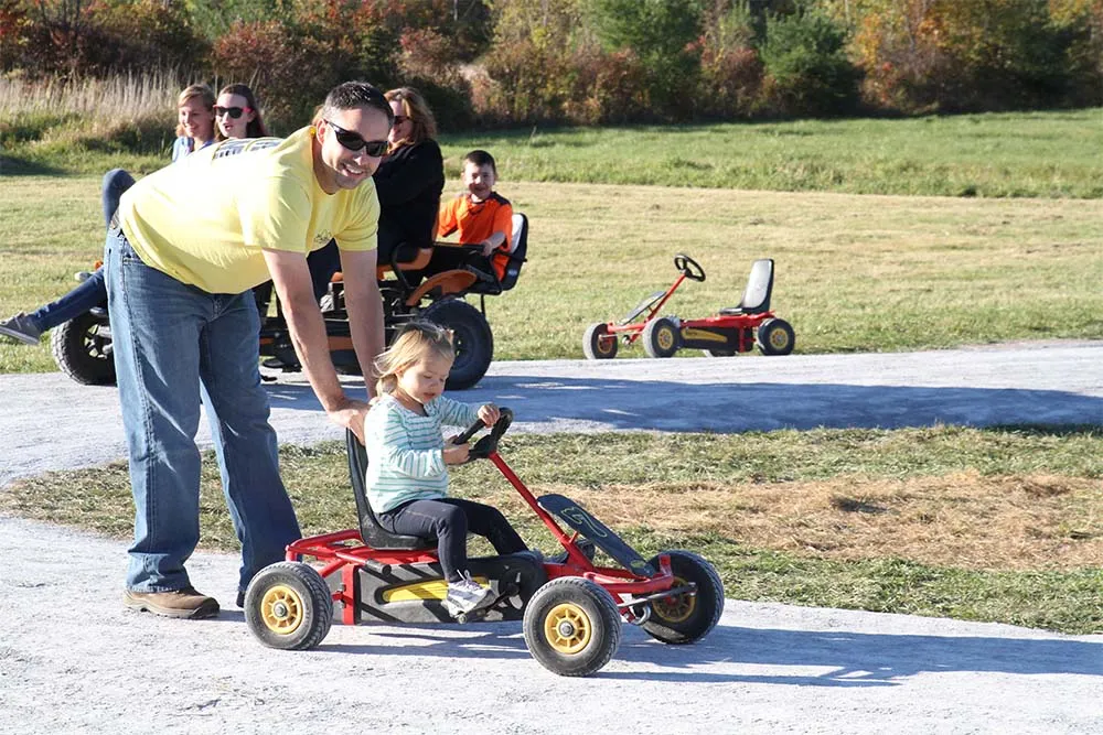dad pushing girl in pedal cart