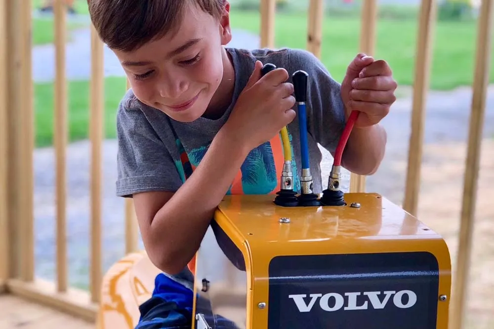 boy controlling toy backhoe
