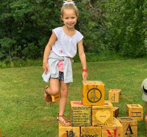 Young girl standing on letter blocks at Ellms Family Farm in Saratoga NY